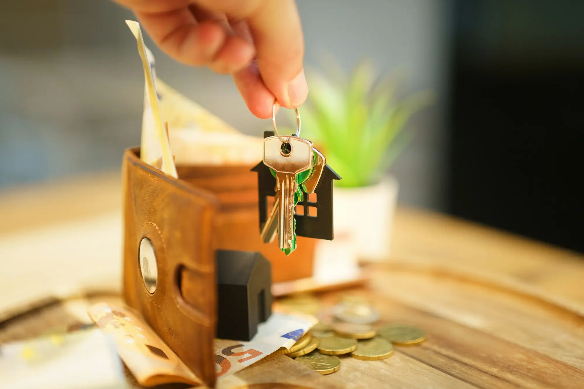 Hand holding house keys, representing property used as security for a business loan