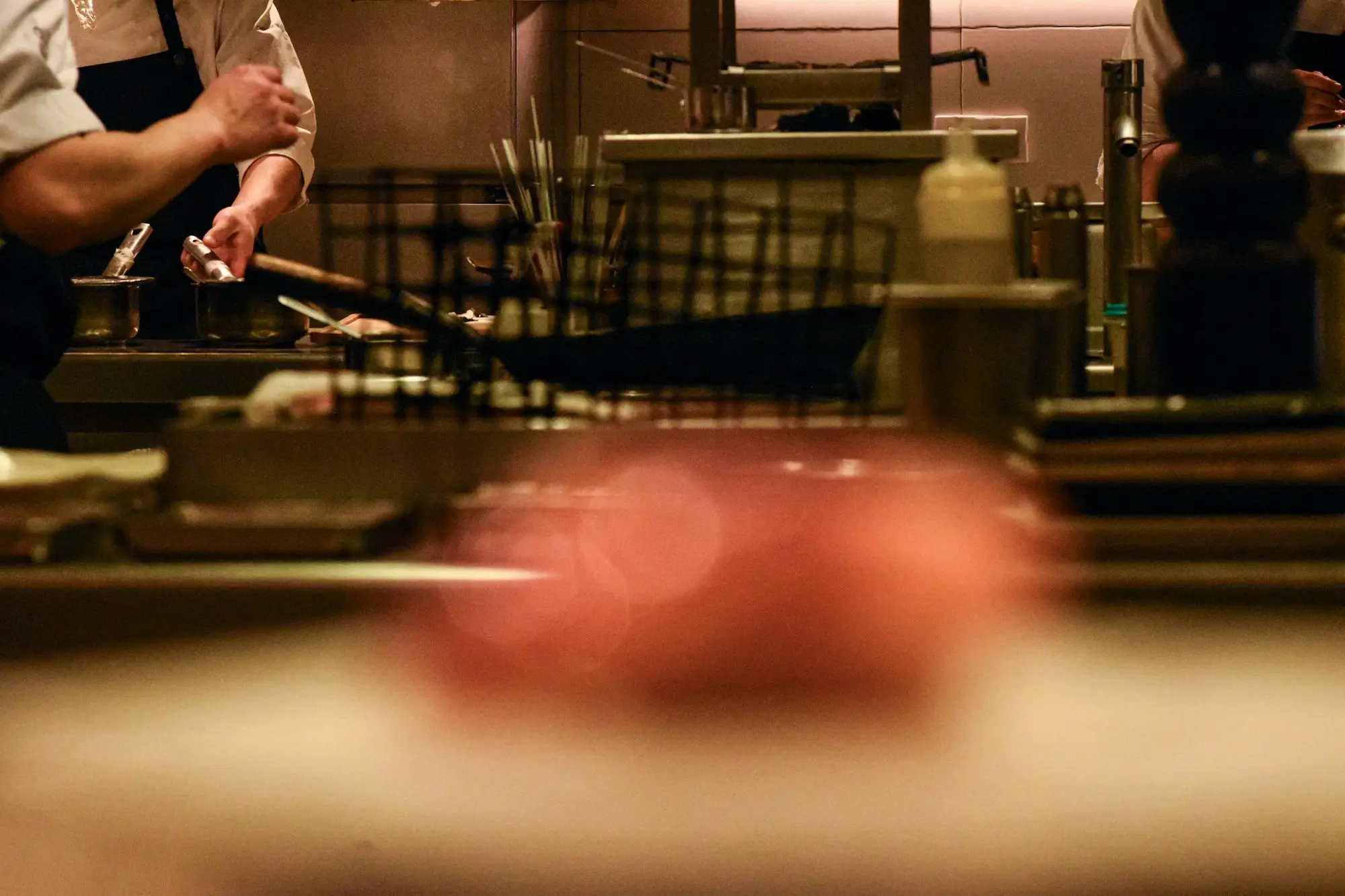 Chefs preparing food in a busy commercial kitchen during service